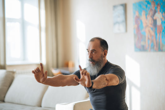 Older man practising a balance exercise at home