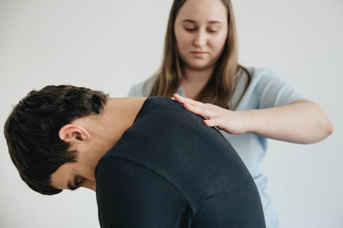 Physiotherapist assessing a patient with back pain