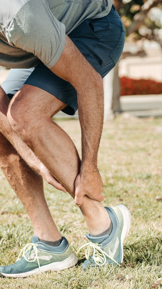 Runner holding his lower leg after developing shin pain